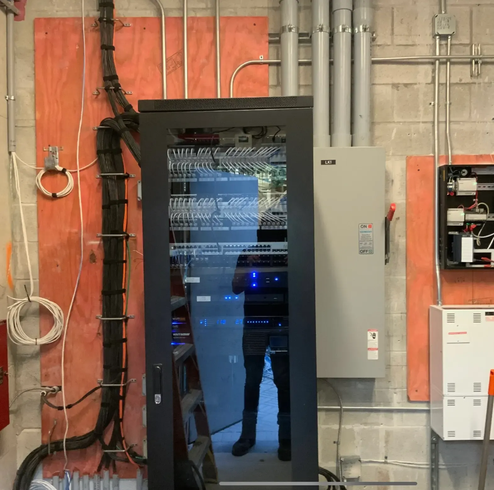 Glass-door network and AV rack installed in a back-of-house room at Amazonico