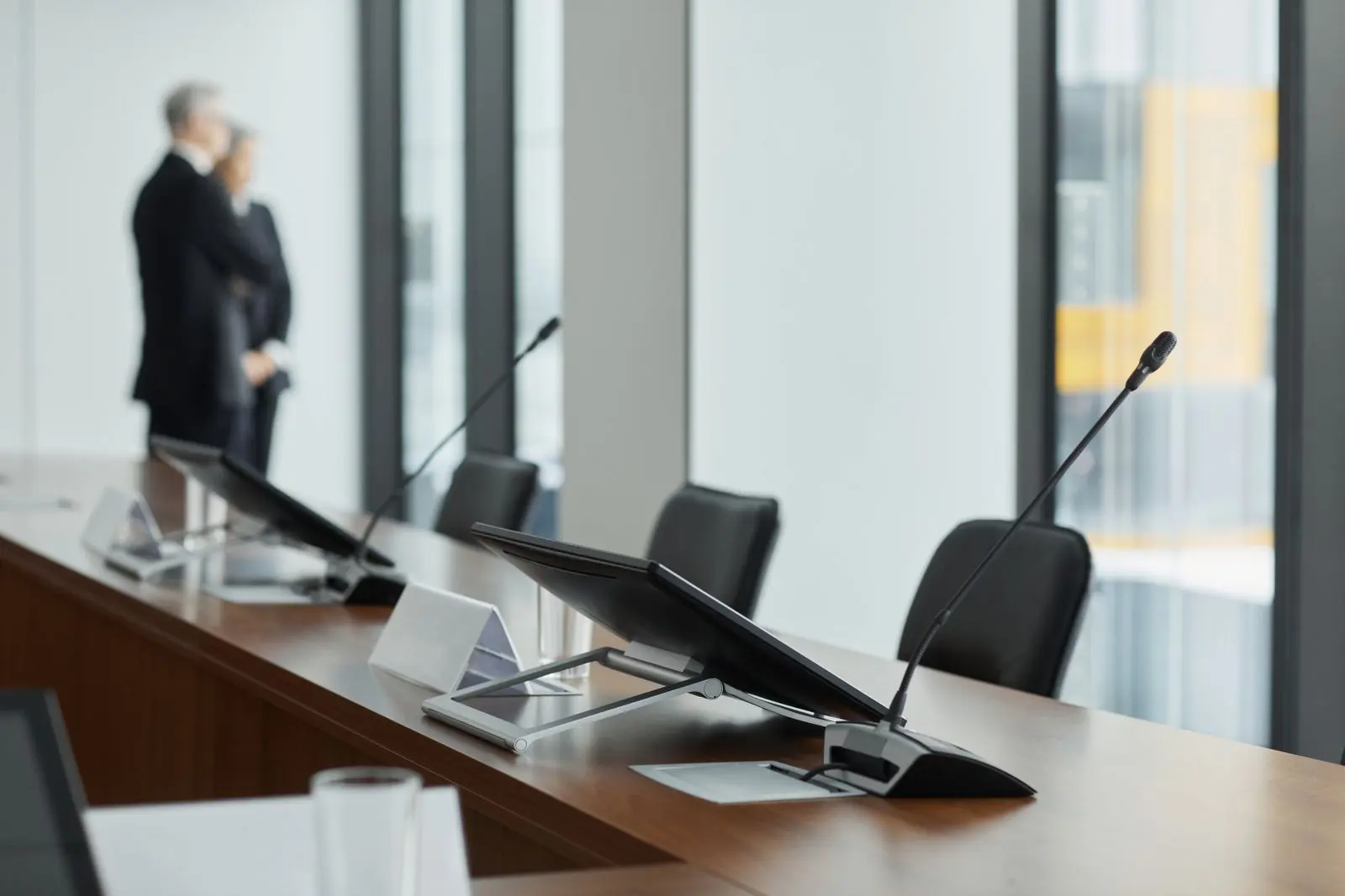 Conference table with gooseneck microphones and tabletop screens