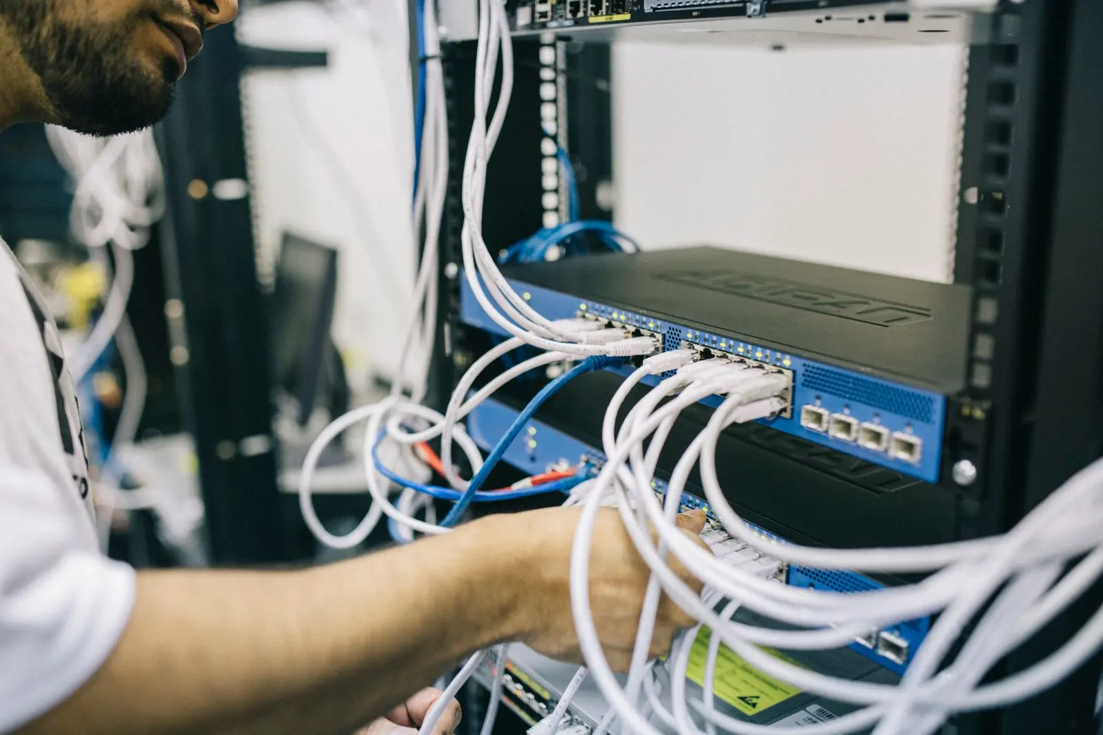 Technician patching network cables into a rack switch