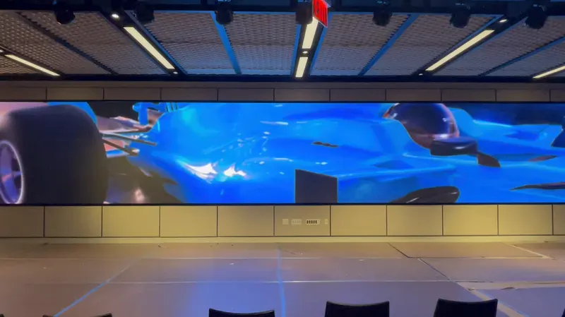 The LED video wall in the same room playing full-width motion content, with chairs set up facing it